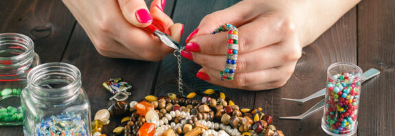 Female stringing beads on the needle
