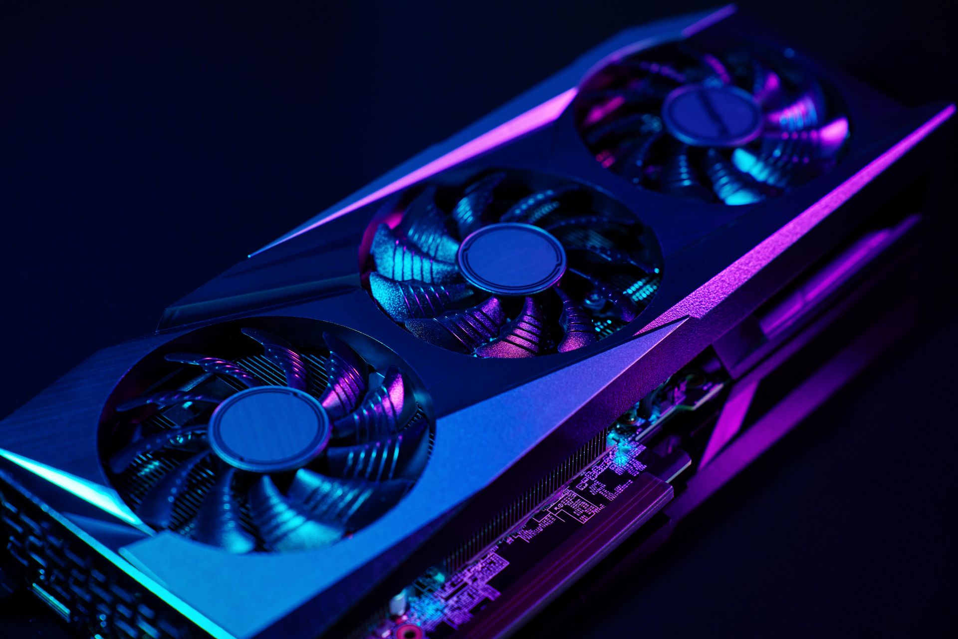 Close-up of a powerful graphics card with triple cooling fans under neon purple and blue lighting – representing performance in gaming servers